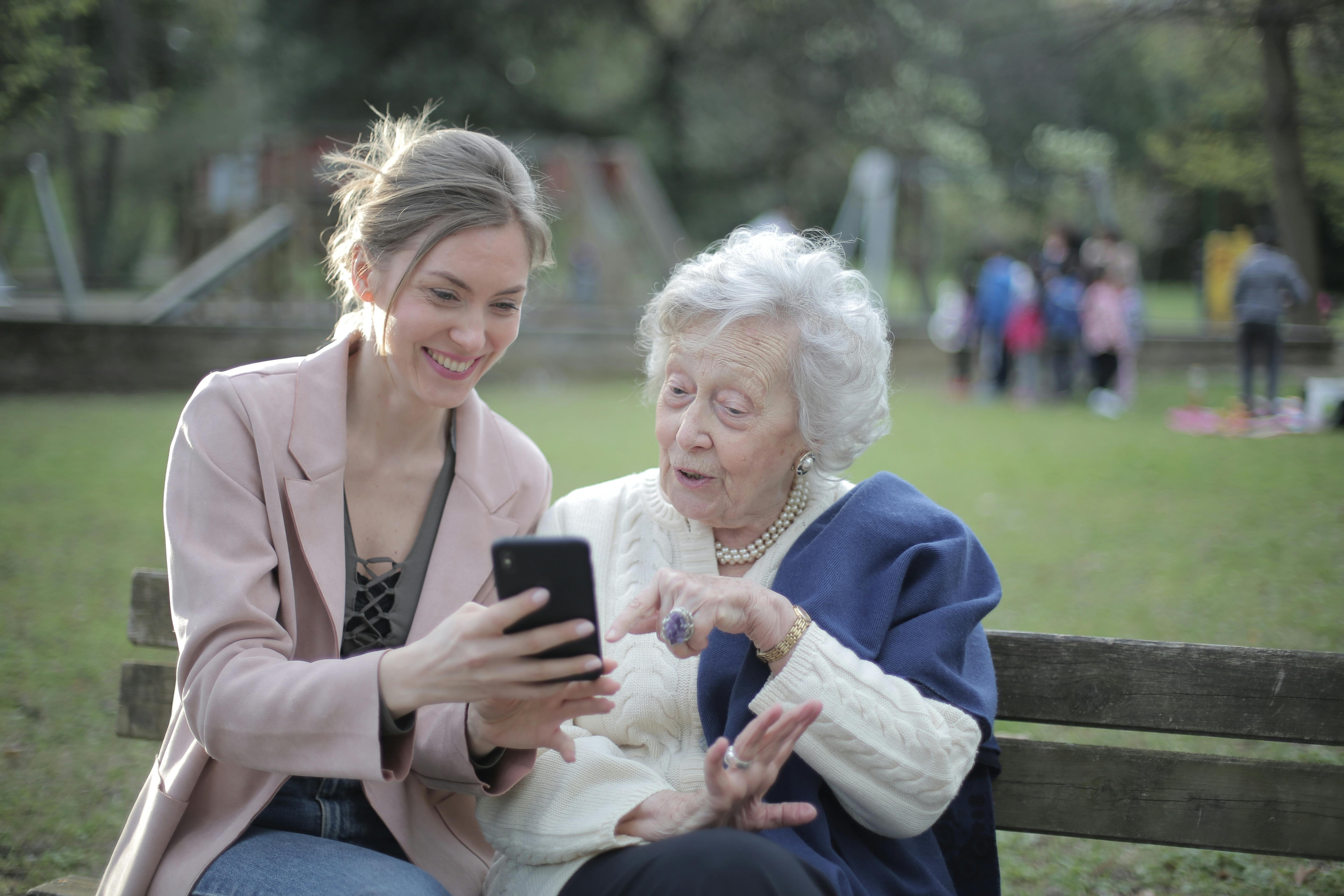Caregiver showing a senior how to use a smartphone